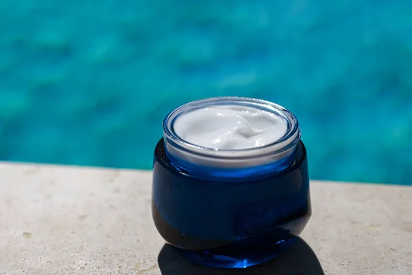 Moisturising beauty cream, skincare and spa cosmetics by swimming pool in summer, cosmetic product and skin care concept