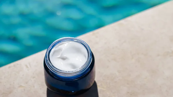 Moisturising beauty cream, skincare and spa cosmetics by swimming pool in summer, cosmetic product and skin care concept