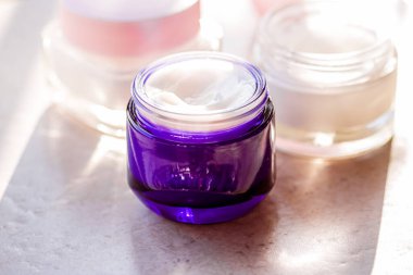 Güzellik kremi kavanozları, cilt bakımı ve kozmetik ürünleri yazın gün batımında taştan arka planda, kozmetik ürünleri ve cilt bakımı konsepti.