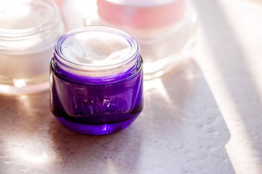 Güzellik kremi kavanozları, cilt bakımı ve kozmetik ürünleri yazın gün batımında taştan arka planda, kozmetik ürünleri ve cilt bakımı konsepti.