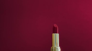 Altın tüpteki kırmızı ruj lüks kozmetik ürün, makyaj ve güzellik markası konsepti.