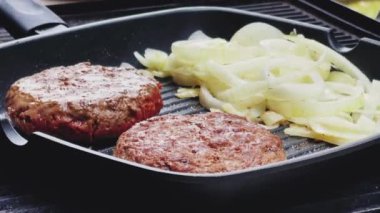 Bahçe konseptinde ızgara et, kızartma tavasında kırmızı et, dökme demir ızgara tavada kıymalı burger pişirmek.