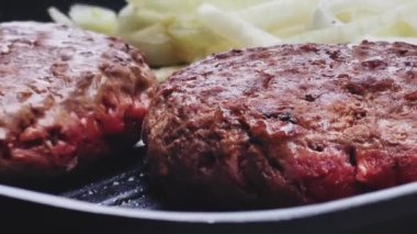 Bahçe konseptinde ızgara et, kızartma tavasında kırmızı et, dökme demir ızgara tavada kıymalı burger pişirmek.