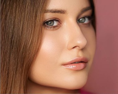 Güzellik, makyaj ve cilt makyajı. Pembe arka planda yüz resmi. Doğal makyajlı güzel bir kadın.