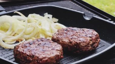 Bahçe konseptinde ızgara et, kızartma tavasında kırmızı et, dökme demir ızgara tavada kıymalı burger pişirmek.