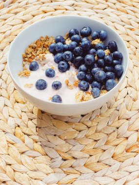 Sağlıklı kahvaltı ve sabah yemeği olarak yaban mersinli yoğurt kasesi, tatlı yemek ve organik meyve, diyet ve beslenme konsepti