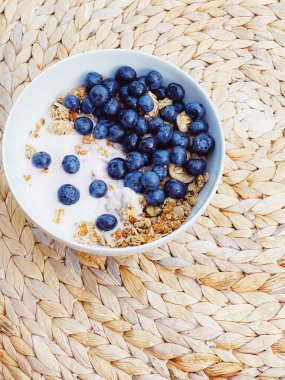 Sağlıklı kahvaltı ve sabah yemeği olarak yaban mersinli yoğurt kasesi, tatlı yemek ve organik meyve, diyet ve beslenme konsepti