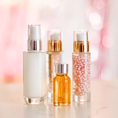 Cilt bakım ürünleri göz kamaştırıcı arka planda, cam şişeler serum, yağ, yüz kremi nemlendirici, yüz losyonu cilt bakımı kozmetik seti, parlak mermer, vücut bakım rutini ve