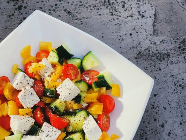 Fresh vegetable greek salad with cherry tomatoes, bell pepper, cucumber, feta cheese, olive oil and seasonal spices, healthy food diet and delicious meal recipe concept
