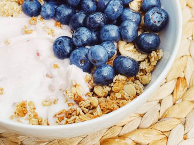Sağlıklı kahvaltı ve sabah yemeği olarak yaban mersinli yoğurt kasesi, tatlı yemek ve organik meyve, diyet ve beslenme konsepti
