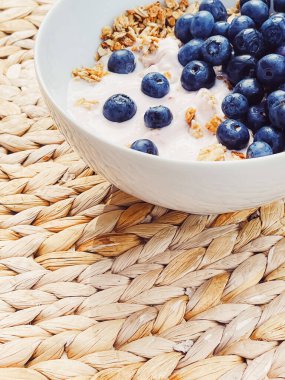 Sağlıklı kahvaltı ve sabah yemeği olarak yaban mersinli yoğurt kasesi, tatlı yemek ve organik meyve, diyet ve beslenme konsepti