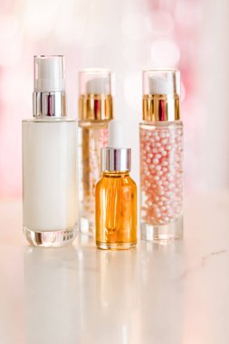 Cilt bakım ürünleri göz kamaştırıcı arka planda, cam şişeler serum, yağ, yüz kremi nemlendirici, yüz losyonu cilt bakımı kozmetik seti, parlak mermer, vücut bakım rutini ve