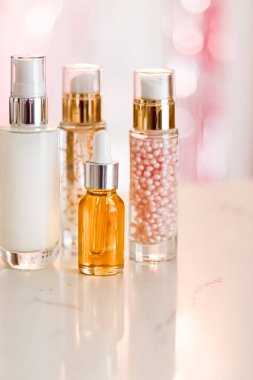 Cilt bakım ürünleri göz kamaştırıcı arka planda, cam şişeler serum, yağ, yüz kremi nemlendirici, yüz losyonu cilt bakımı kozmetik seti, parlak mermer, vücut bakım rutini ve