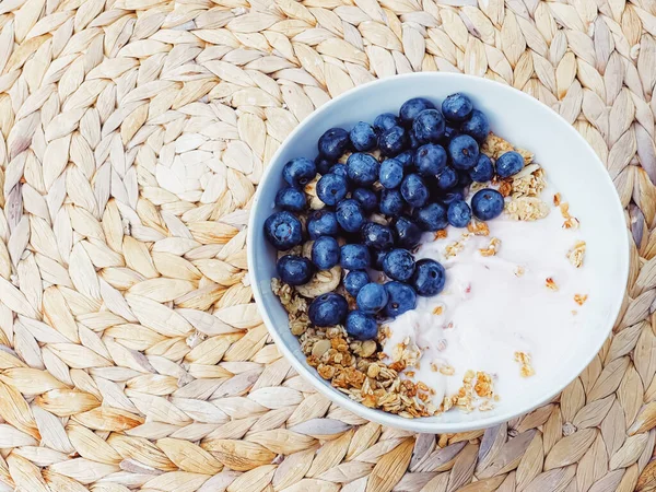 Sağlıklı kahvaltı ve sabah yemeği olarak yaban mersinli yoğurt kasesi, tatlı yemek ve organik meyve, diyet ve beslenme konsepti