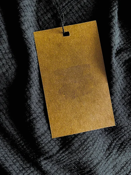 Blank fashion label tag, sale price card on luxury fabric background, shopping and retail concept