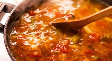 Cooking vegetable soup in saucepan, comfort food and homemade meal concept
