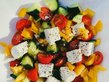 Fresh vegetable greek salad with cherry tomatoes, bell pepper, cucumber, feta cheese, olive oil and seasonal spices, healthy food diet and delicious meal recipe concept