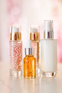 Cilt bakım ürünleri göz kamaştırıcı arka planda, cam şişeler serum, yağ, yüz kremi nemlendirici, yüz losyonu cilt bakımı kozmetik seti, parlak mermer, vücut bakım rutini ve