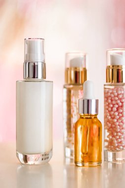 Cilt bakım ürünleri göz kamaştırıcı arka planda, cam şişeler serum, yağ, yüz kremi nemlendirici, yüz losyonu cilt bakımı kozmetik seti, parlak mermer, vücut bakım rutini ve