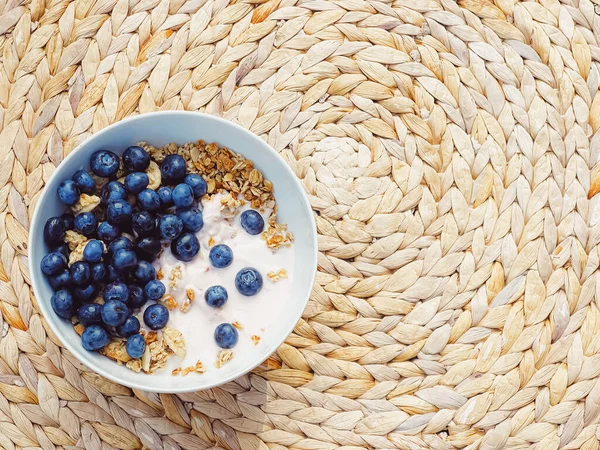 Sağlıklı kahvaltı ve sabah yemeği olarak yaban mersinli yoğurt kasesi, tatlı yemek ve organik meyve, diyet ve beslenme konsepti