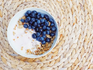 Sağlıklı kahvaltı ve sabah yemeği olarak yaban mersinli yoğurt kasesi, tatlı yemek ve organik meyve, diyet ve beslenme konsepti