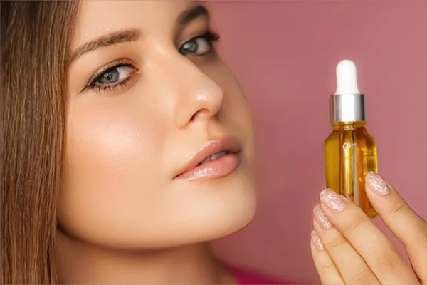 Beauty, makeup and skincare cosmetics model face portrait, woman holding skin care cosmetic essential oil bottle with dropper, luxury facial care product mockup