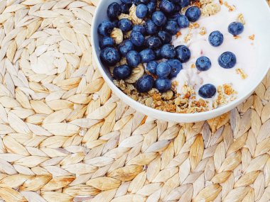Sağlıklı kahvaltı ve sabah yemeği olarak yaban mersinli yoğurt kasesi, tatlı yemek ve organik meyve, diyet ve beslenme konsepti