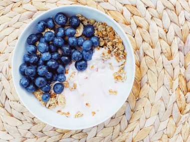 Sağlıklı kahvaltı ve sabah yemeği olarak yaban mersinli yoğurt kasesi, tatlı yemek ve organik meyve, diyet ve beslenme konsepti