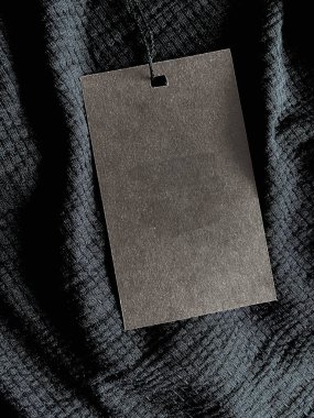 Blank fashion label tag, sale price card on luxury fabric background, shopping and retail concept