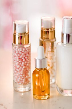 Cilt bakım ürünleri göz kamaştırıcı arka planda, cam şişeler serum, yağ, yüz kremi nemlendirici, yüz losyonu cilt bakımı kozmetik seti, parlak mermer, vücut bakım rutini ve