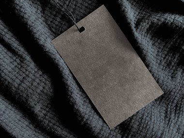 Blank fashion label tag, sale price card on luxury fabric background, shopping and retail concept