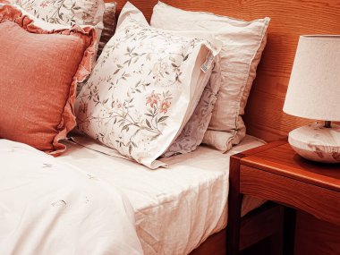 Vintage countryside style bedding with floral pattern on wooden bed in bedroom, interior design detail