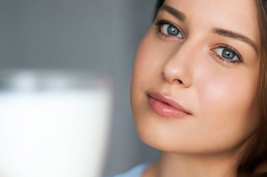 Diet and wellness, young woman with glass of milk or protein shake cocktail, portrait