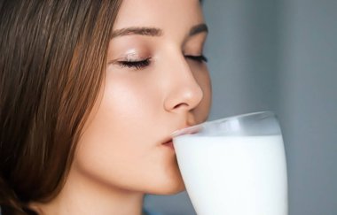 Diet and wellness, young woman drinking milk or protein shake cocktail, portrait