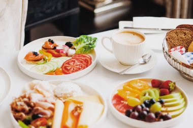 Lüks otel ve beş yıldızlı oda servisi, çeşitli yemek tabakları, ekmek ve kahve seyahat ve konukseverlik markası olarak oda kahvaltısı.