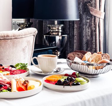 Lüks otel ve beş yıldızlı oda servisi, çeşitli yemek tabakları, ekmek ve kahve seyahat ve konukseverlik markası olarak oda kahvaltısı.