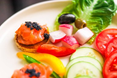Somon, siyah havyar ve konukseverlik ve gastronomi için taze sebze dilimlenmiş aperatif tabağı.