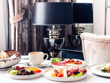 Lüks otel ve beş yıldızlı oda servisi, çeşitli yemek tabakları, ekmek ve kahve seyahat ve konukseverlik markası olarak oda kahvaltısı.