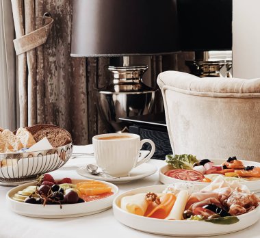 Lüks otel ve beş yıldızlı oda servisi, çeşitli yemek tabakları, ekmek ve kahve seyahat ve konukseverlik markası olarak oda kahvaltısı.