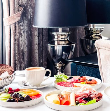 Lüks otel ve beş yıldızlı oda servisi, çeşitli yemek tabakları, ekmek ve kahve seyahat ve konukseverlik markası olarak oda kahvaltısı.