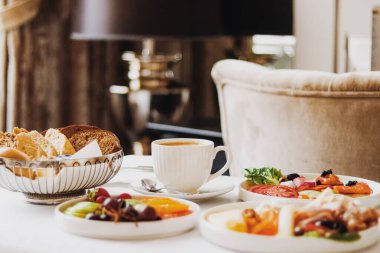 Lüks otel ve beş yıldızlı oda servisi, çeşitli yemek tabakları, ekmek ve kahve seyahat ve konukseverlik markası olarak oda kahvaltısı.