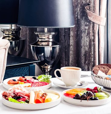 Lüks otel ve beş yıldızlı oda servisi, çeşitli yemek tabakları, ekmek ve kahve seyahat ve konukseverlik markası olarak oda kahvaltısı.