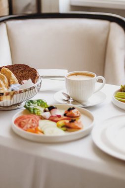 Lüks otel ve beş yıldızlı oda servisi, çeşitli yemek tabakları, ekmek ve kahve seyahat ve konukseverlik markası olarak oda kahvaltısı.