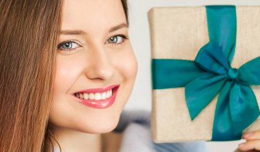 Kış tatili, hediye ve mutlu Noeller, gülümseyen ve paketlenmiş hediye kutusu tutan mutlu kadın, yakın plan portresi.