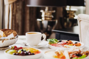 Lüks otel ve beş yıldızlı oda servisi, çeşitli yemek tabakları, ekmek ve kahve seyahat ve konukseverlik markası olarak oda kahvaltısı.