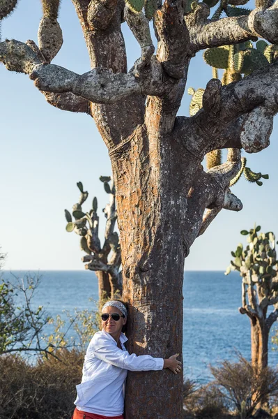 Woman embracing Galapagos cactus tree — Stock Photo, Image