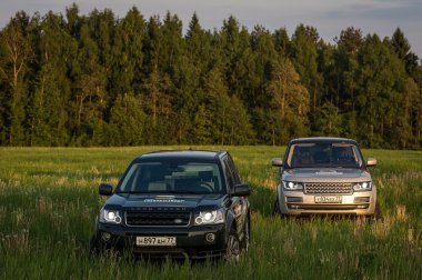 Suv cars in high grass of russian field clipart