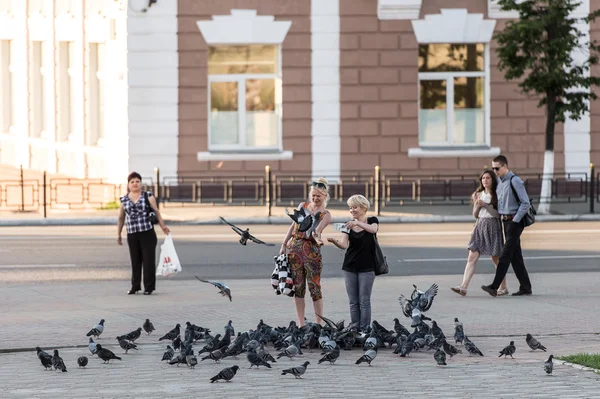 Palomas de alimentación Townsfolk en una calle de la ciudad de Vladimir, Rusia — Foto de Stock