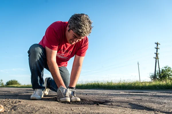 Repairing road with cold-mix asphalt on a rural russian road — Stock Photo, Image