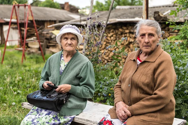 To senior russiske damer taler på en bænk - Stock-foto